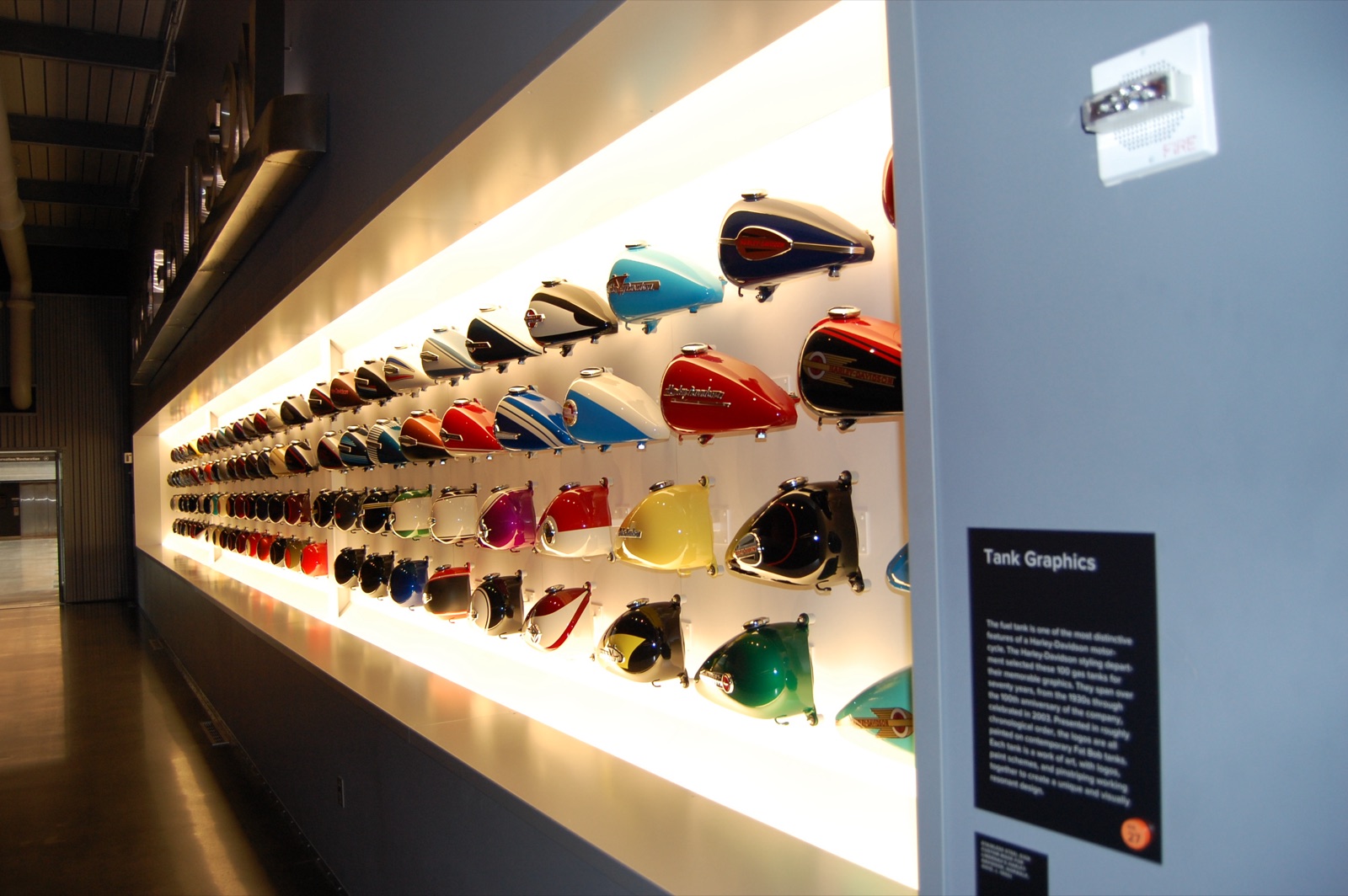 Harley-Davidson Museum Tank Wall exhibit displaying decades of motorcycle fuel tank graphics